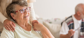 Elderly woman in wheelchair holding hand